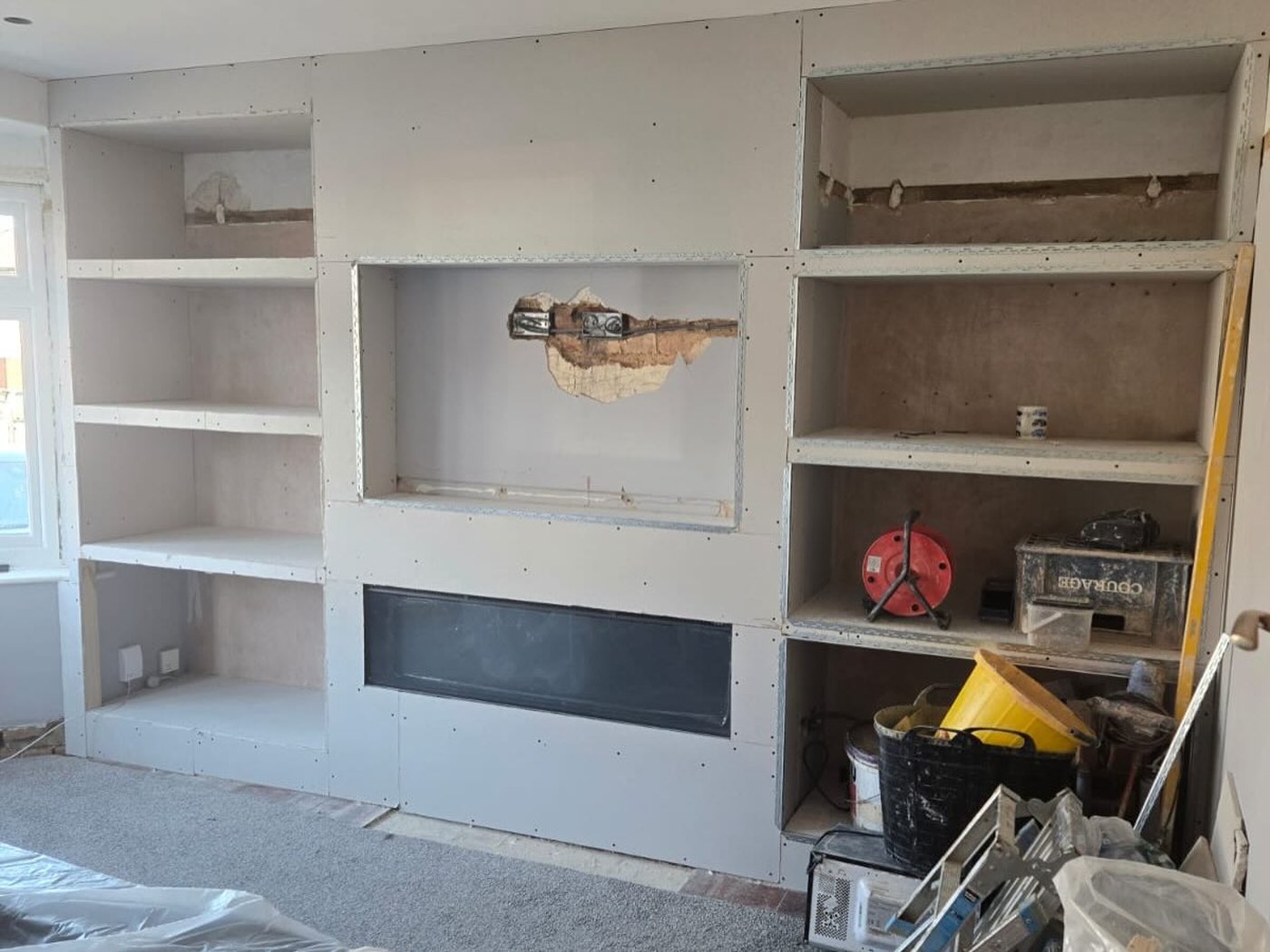 A media wall under construction, showing the timber framing before boarding