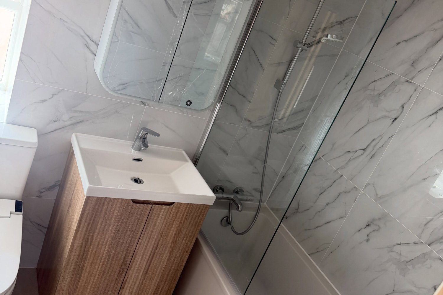 A marble tiled en suite shower room inside a loft conversion